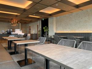 a restaurant with tables and chairs in a room at Royal Park Hotel Kurashiki in Kurashiki