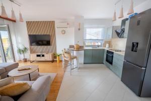 una cucina e un soggiorno con frigorifero in acciaio inossidabile di Apartments Ana-Maria a Fažana