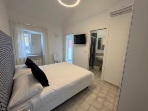 a bedroom with a bed with a black pillow on it at Mana House2 in Maiori
