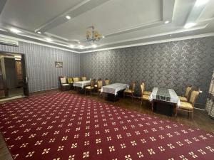 a waiting room with tables and chairs and a red carpet at Mumtoz Plaza in Bukhara