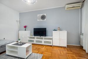 a white living room with a flat screen tv at Dea B4+1 in Poreč