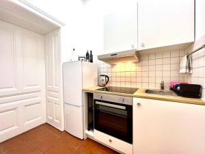a kitchen with a white refrigerator and a sink at little cozy residence - enjoy Viennas summer season in Vienna
