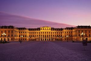 a large yellow building at night with a purple sky at little cozy residence - enjoy Viennas summer season in Vienna