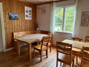 a dining room with a table and chairs and a window at Nya Skogsgården Hostel in Torsby