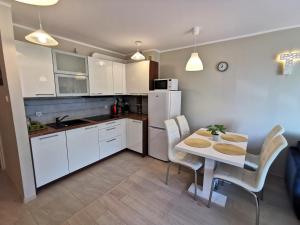 a kitchen and dining room with a table and chairs at Apart Harmony - Apartamenty Przy Zatoce in Puck