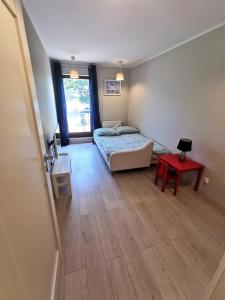 um quarto com uma cama e uma mesa vermelha em Apart Harmony - Apartamenty Przy Zatoce em Puck
