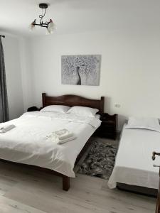 a bedroom with two beds with white sheets at Cazare Nely in Novaci-Străini