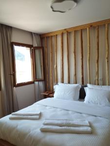 - une chambre avec 2 serviettes blanches sur un lit dans l'établissement Primula, à Metsovo