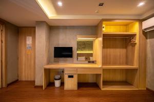 Habitación con escritorio, TV y espejo. en Patong Poshtel, en Patong Beach