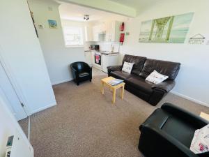 ein Wohnzimmer mit einem Sofa und einem Tisch in der Unterkunft 2 Bedroom Chalet SB113, Sandown Bay, Isle of Wight in Brading