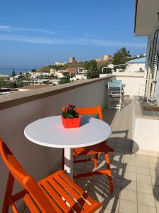 una mesa y sillas en un balcón con vistas al océano en La Bussola en Porto Palo