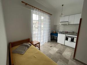 a small kitchen with a bed in a room at Studio Bellos in Tolo