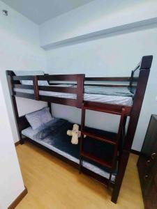 two bunk beds in a room with a teddy bear at Fully-Airconditioned 2-BR Unit near BGC in Manila