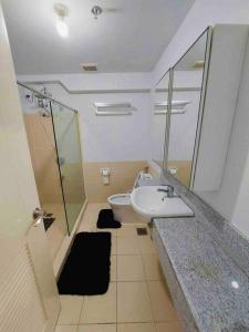 a bathroom with a sink and a shower and a toilet at Fully-Airconditioned 2-BR Unit near BGC in Manila