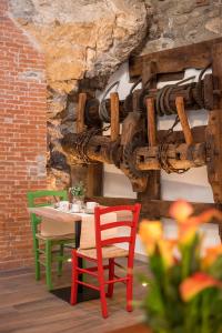 a table and chairs in a room with a stone wall at Porto di Clanezzo in Clanezzo