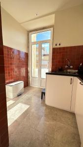uma cozinha com um balcão, uma janela e um lavatório em Eco Luxury apartment LISBOA-Campo de Ourique em Lisboa