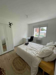 1 dormitorio con cama, escritorio y ventana en Maison cosy, Rouen, en Déville-lès-Rouen