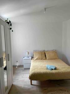 1 dormitorio con cama y pared blanca en Maison cosy, Rouen, en Déville-lès-Rouen