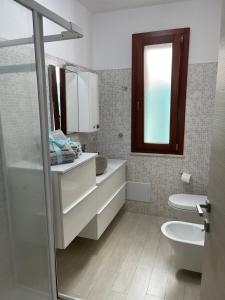uma casa de banho com um WC, um lavatório e um espelho. em À Grancéa em Calasetta