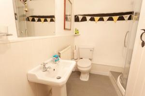 Baño blanco con aseo y lavamanos en Cosy Nook en North Molton