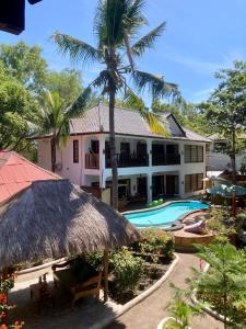 a house with a palm tree and a swimming pool at Lutwala Bungalows and Private Villa in Gili Trawangan