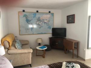 - un salon avec une télévision et une carte murale dans l'établissement Casita Mona - Attractive Studio Apartment 4kms from the beach, à Moraira