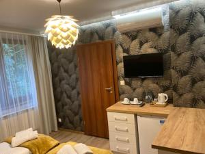 Zimmer mit einer Küche, einem Schreibtisch und einem TV. in der Unterkunft Leśna Polana in Radawa