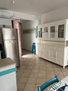 uma cozinha com armários brancos e um frigorífico de aço inoxidável em À Grancéa em Calasetta