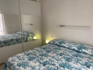 małą sypialnię z łóżkiem i lustrem w obiekcie À Grancéa w mieście Calasetta