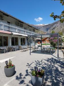 a hotel with tables and chairs in a parking lot at Hotel Restaurant Lancheton in Saint-Julien-Mont-denis