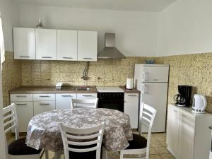 a kitchen with a table with chairs and a refrigerator at Villa Roseal in Povljana