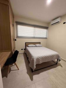 1 dormitorio con 1 cama, 1 silla y 1 ventana en Departamento de lujo nuevo con Alberca y Gimnasio, en Ciudad Obregón