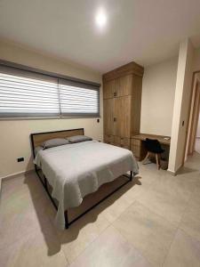 una camera con un grande letto e una scrivania di Departamento de lujo nuevo con Alberca y Gimnasio a Ciudad Obregón
