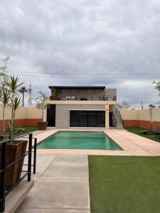 una casa con piscina frente a un edificio en Departamento de lujo nuevo con Alberca y Gimnasio, en Ciudad Obregón