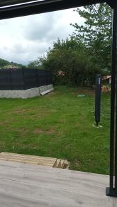 une vue sur un champ d'herbe avec une clôture dans l'établissement Loft sauna jacuzzi ospariegeois, à Lavelanet