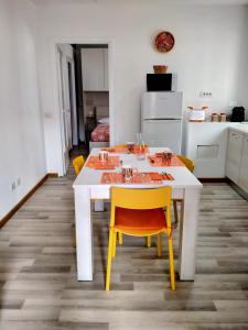 - une table blanche avec des chaises jaunes dans la cuisine dans l'établissement casArancia, à Rome