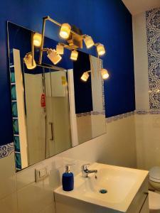 een badkamer met een wastafel, een spiegel en een toilet bij casArancia in Rome