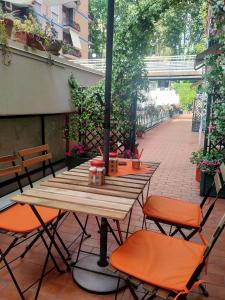 a wooden table with orange chairs on a patio at casArancia in Rome