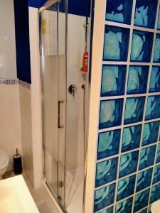 een douche met een glazen deur in de badkamer bij casArancia in Rome