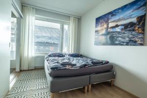 um quarto com uma cama em frente a uma janela em Beautiful penthouse in the center of Helsinki em Helsinque