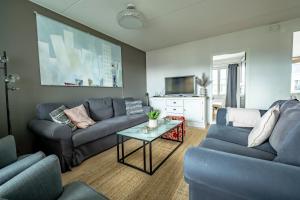 a living room with blue couches and a tv at Beautiful penthouse in the center of Helsinki in Helsinki