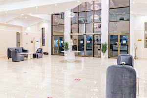 een lobby met stoelen en tafels in een gebouw bij Mooj Apartments Hotel- فندق موج للشقق الفندقية in Dammam