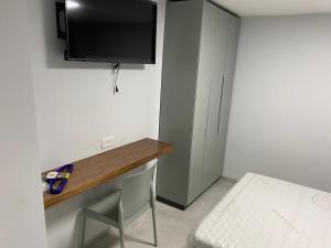 Mevasseret Zion的住宿－בוטיק בהרי הקסטל，小房间设有一张桌子和一台墙上的电视