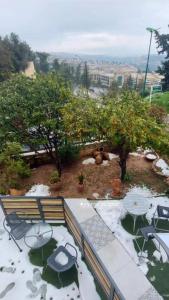 widok na ogród z krzesłami i drzewami w obiekcie בוטיק בהרי הקסטל w mieście Mevasseret Zion