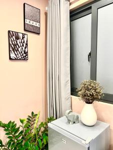 a white vase sitting on a white table in front of a mirror at MIDMOST Boutique Hostel in Can Tho