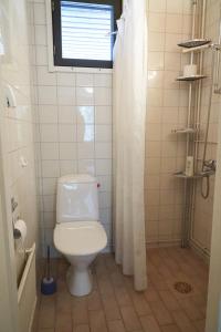 La salle de bains est pourvue de toilettes blanches et d'une fenêtre. dans l'établissement Rantasaunallinen yksiö, à Virrat