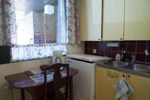 a small kitchen with a table and a sink and a counter at Rantasaunallinen yksiö in Virrat