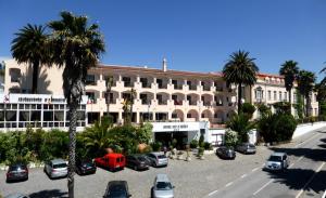 um grande edifício com carros estacionados num parque de estacionamento em Hotel Sol e Serra em Castelo de Vide