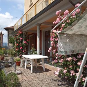 a white table sitting outside of a building with pink flowers at Villa Giulia in Lura