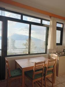 uma cozinha com mesa e cadeiras e uma grande janela em Captain's panoramic sea view em Sami